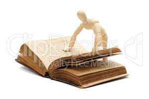 wooden doll reading a book