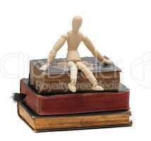 wooden doll sit on old books