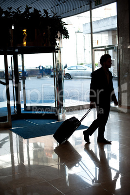 Man entering hotel lobby with his luggage
