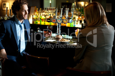 Attractive couple refreshing themselves at the bar