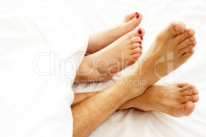 Closeup of bare feet of love couple, making out