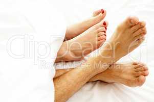 Closeup of bare feet of love couple, making out