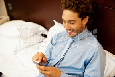 Busy young man surfing menu of his new phone