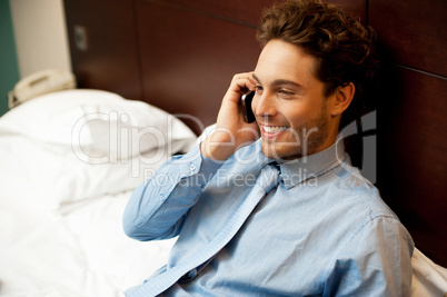 Young man conversing on mobile phone
