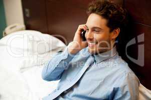 Young man conversing on mobile phone