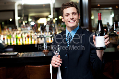 Cheerful executive posing with a bottle of wine