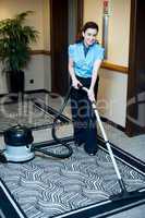 Staff cleaning carpet with a vacuum cleaner