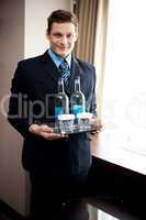 Male butler holding fresh beverages for customers