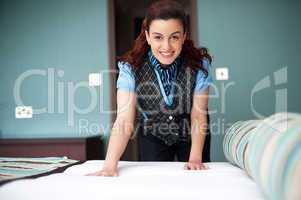 Smiling female executive giving final touches to master bedroom