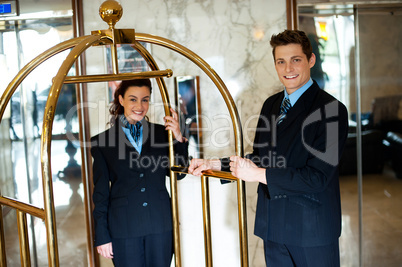 Concierges holding the cart and posing