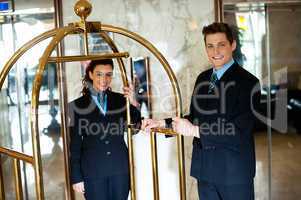 Concierges holding the cart and posing