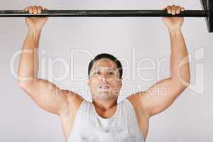 Athlete pull oneself up on gym background
