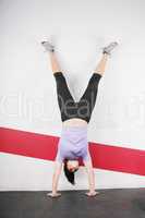 Brunette handstand woman isolated on gym