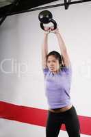 Athletic young woman doing a fitness workout with Kettlebell wei