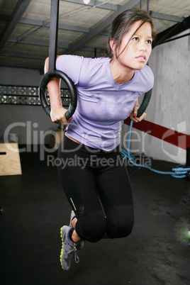 young woman on rings on gym
