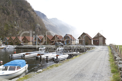 small harbor with mountains and houses in background