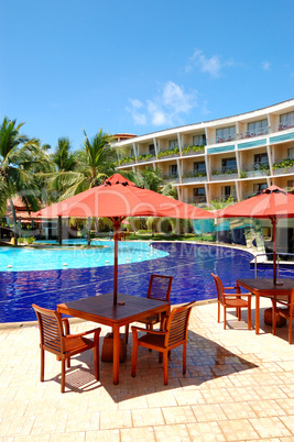 The table and chairs of outdoor restaurant near swimming pool at