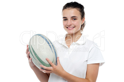 Attractive sporty girl posing with rugby ball