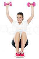 Young girl sitting on floor and doing fitness exercise
