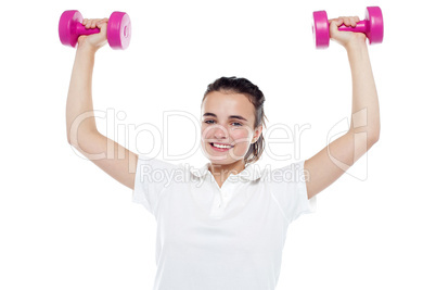 Smiling girl working out. Dumbbells above her head