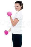 Side pose of girl with dumbbells working out