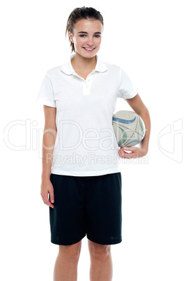 Sporty young girl holding a rugby ball