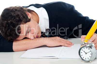 Teenager dozing off while writing his test