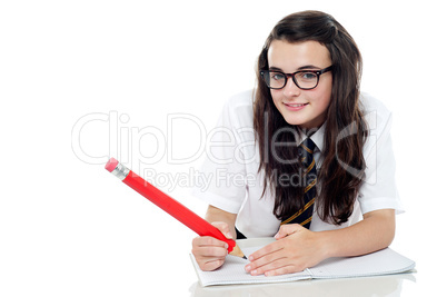 Bespectacled schoolgirl with long hair studying