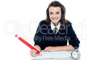 Profile shot of smiling school girl taking down notes