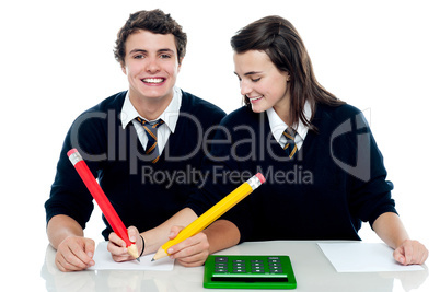 Girl making corrections on her partners examination paper