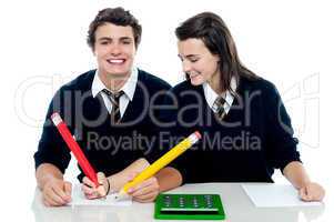 Girl making corrections on her partners examination paper