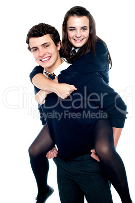 Girl riding piggyback and embracing boy tightly