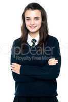 Confident schoolgirl posing with folded arms