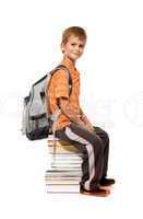 Schoolboy sitting on books