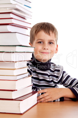 Schoolboy and a heap of books isolated on a white background