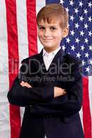 Portait of Caucasian boy with American flag in background.