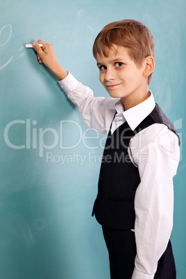 School student writing on blackboard at school