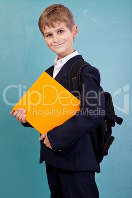 Ñute schoolboy is holding an orange book