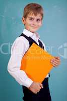 Ñute schoolboy is holding an orange book