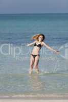 Frau mit Bikini springt im meer hochformat