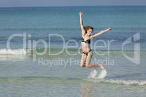 Frau mit Bikini springt im meer Querformat