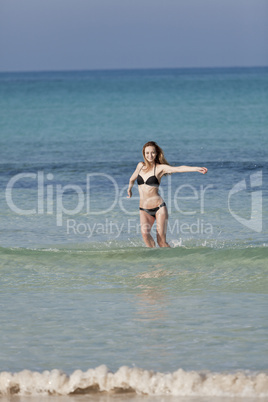 Frau mit Bikini im meer beim Springen Hochformat