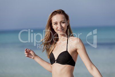 Junge Frau mit Bikini lachend am Strand Portrait Querformat