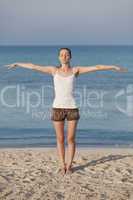 Frau macht yoga Sport am Strand Hochformat