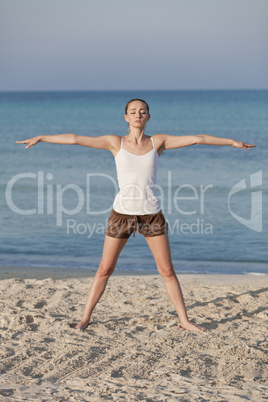 Frau macht yoga Sport am Strand Hochformat