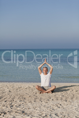 Mann macht yoga Sport am Strand Hochformat