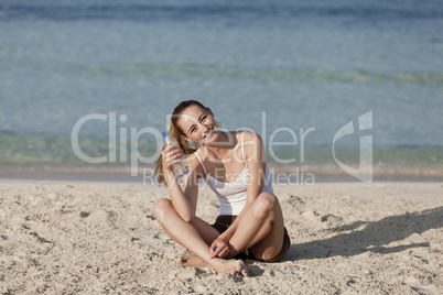 Frau trinkt wasser aus einer flasche am Strand Querformat