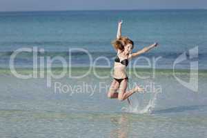 Frau mit Bikini springt im meer Querformat