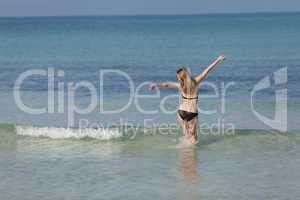 Frau mit Bikini im meer beim Springen Querformat