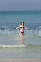 Frau mit Bikini im meer beim Springen Hochformat